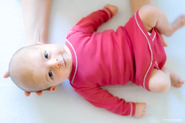 kinderosteopathie_05 Baby mit pinkem Strampler