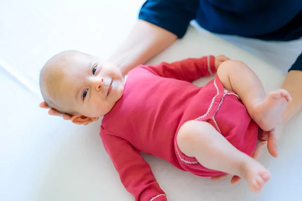 kinderosteopathie_12 Baby im pinkem Strampler